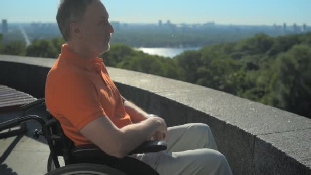 Pensativo homem com rodas apreciando a vista da cidade — Vídeo de Stock