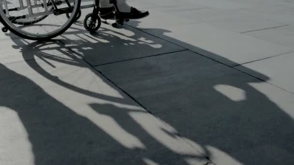 Helpful man pushing a wheelchair with differently abled person — Stock Video