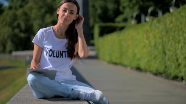 Vrolijke vrouw vrijwilligers zitten in het park — Stockvideo