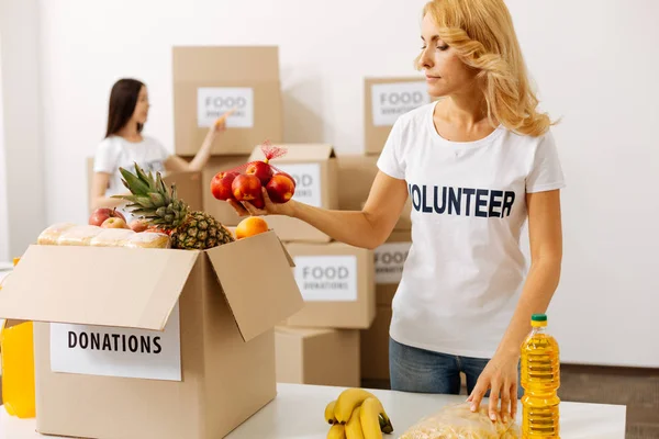 Energisk uppmärksam kvinna förpackning frukter — Stockfoto