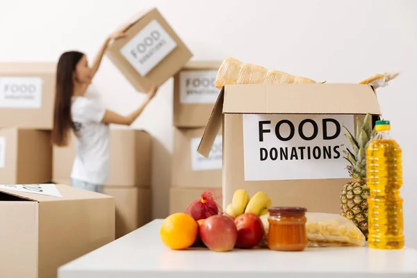 Charismatic active lady moving the boxes in a warehouse — Stock Photo, Image