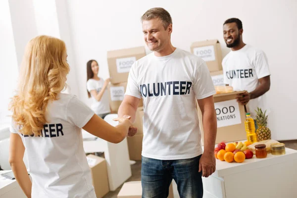 Vänlig trevlig man skakar hand med ny Volontär — Stockfoto