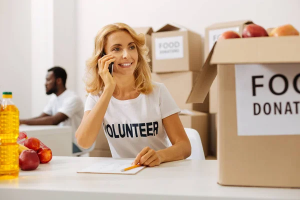 Aktiva produktiv kvinna ringer från en välgörenhetsorganisation office — Stockfoto