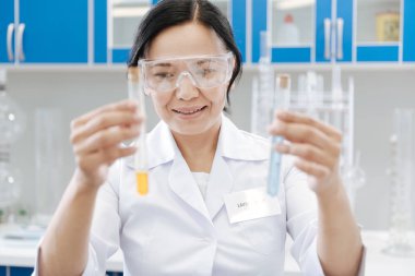 Test tüpleri tutan neşeli akıllı kadın