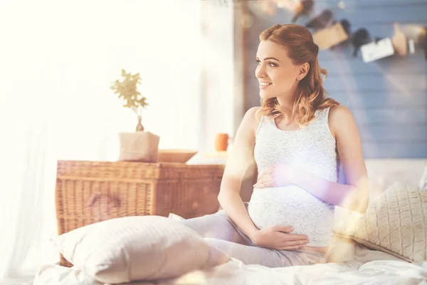 Fröhliche Schwangere ruht sich im Bett aus — Stockfoto