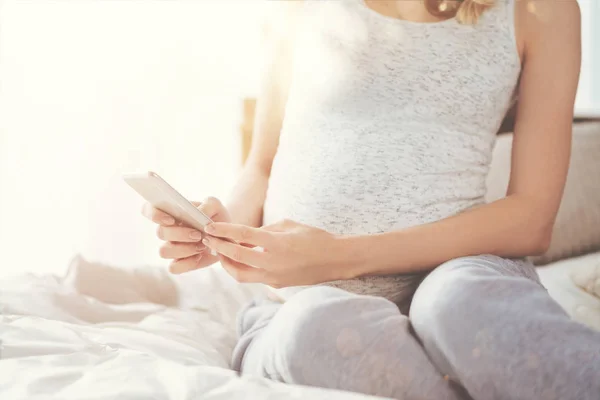 Gravid kvinna som använder smarttelefon — Stockfoto