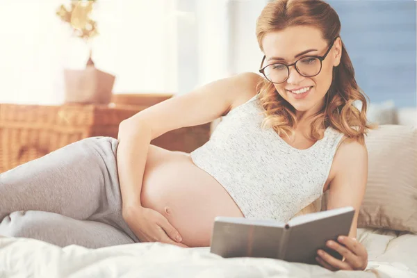 Mulher grávida alegre lendo um livro — Fotografia de Stock