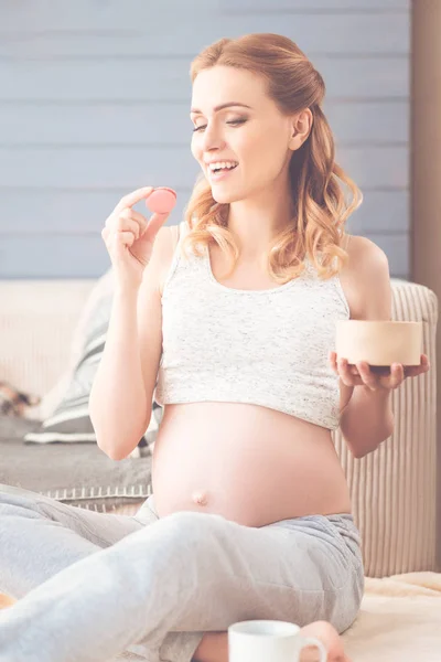 Gravid kvinna äta mandelbiskvier — Stockfoto