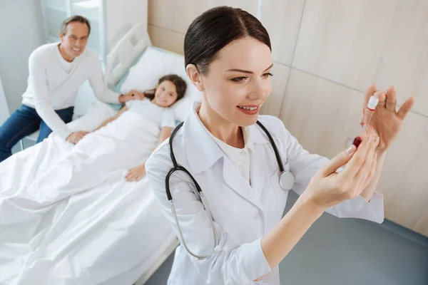 Trevliga glada läkare tittar på blodprovet — Stockfoto