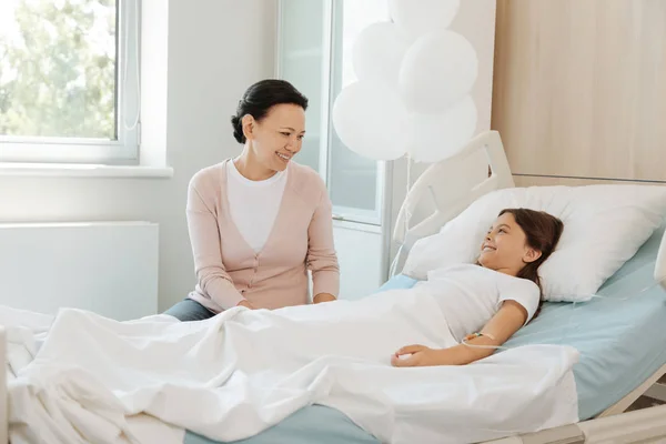 Madre sentada cerca de la cama hijas — Foto de Stock