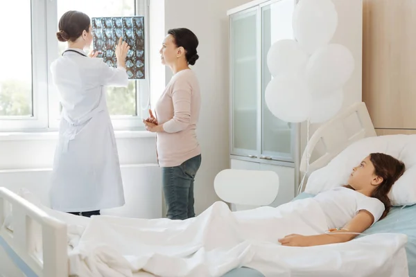Arzt zeigt Mutter des Patienten Röntgenbild — Stockfoto