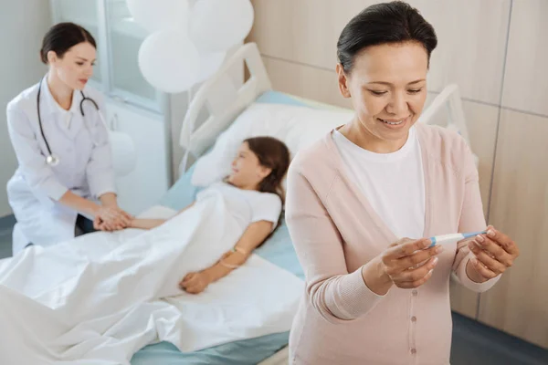 Mujer positiva feliz mirando el termómetro — Foto de Stock