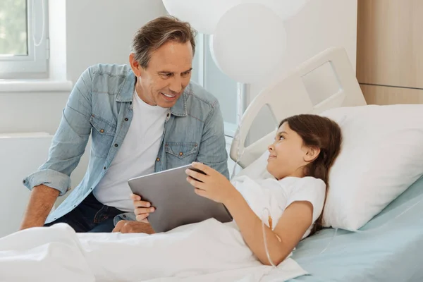 Chica mostrando juego en tableta a padre — Foto de Stock