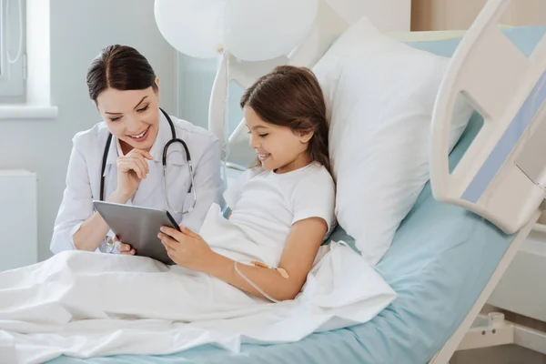 Menina mostrando jogo para médico — Fotografia de Stock