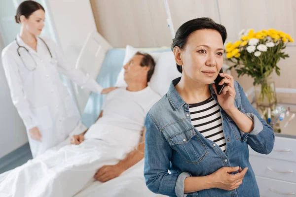 Hermosa mujer agradable sosteniendo su teléfono celular — Foto de Stock