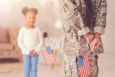 Amerikan bayrağı tutarak askeri üniformalı kadın