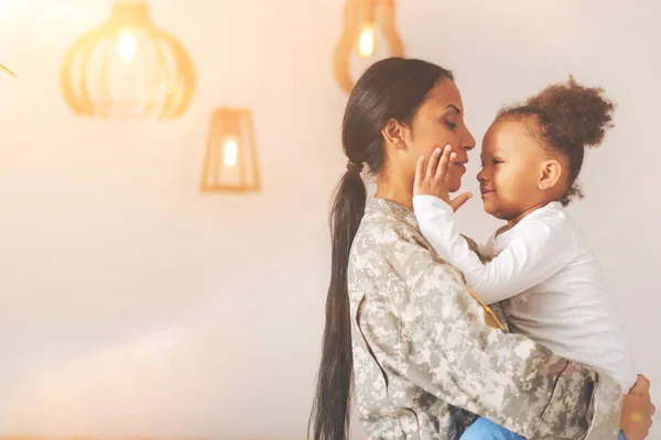 Schattig meisje aanraken van de wangen van haar moeder — Stockfoto