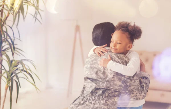 Ευτυχισμένη κόρη αγκαλιάζει τη μητέρα-στρατιώτη — Φωτογραφία Αρχείου