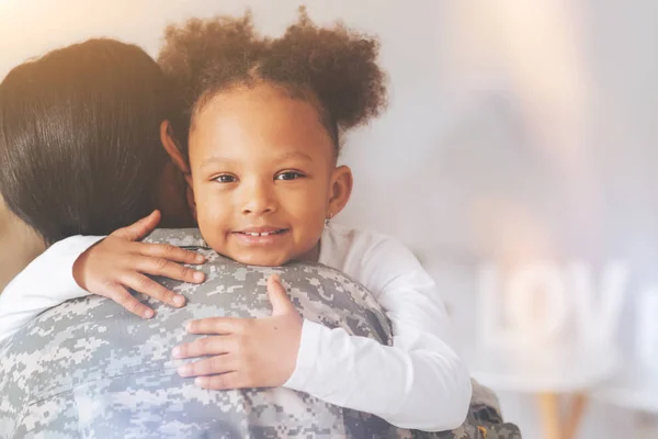 Happy little girl hugging her mother wearing camouflage — Stock Photo, Image