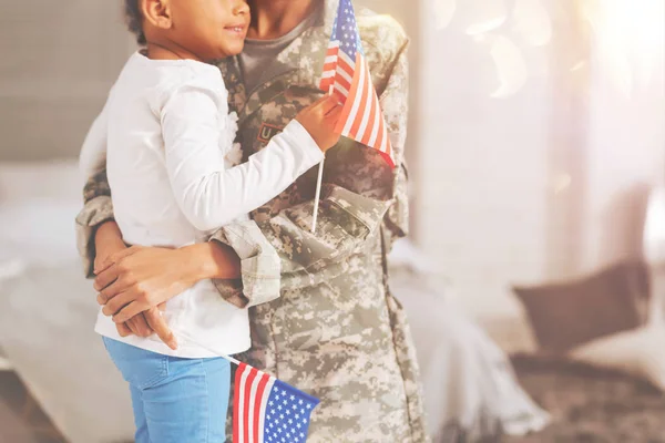 Handen van een militaire moeder haar zoete kind knuffelen — Stockfoto