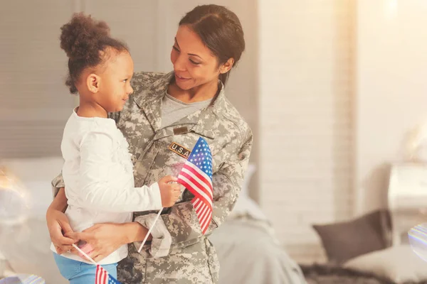 Militärmutter spricht mit Tochter, während sie sie umarmt — Stockfoto