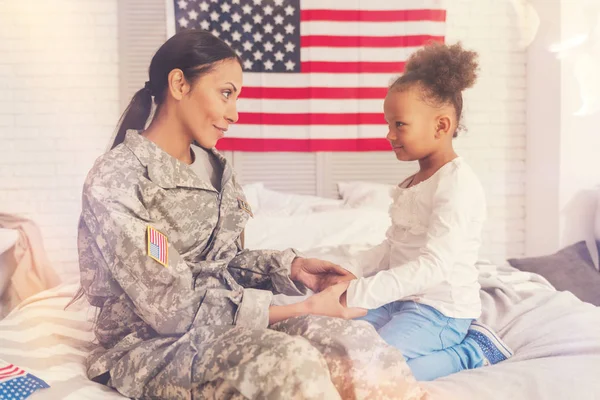 Військова мати тримає руки дочок — стокове фото