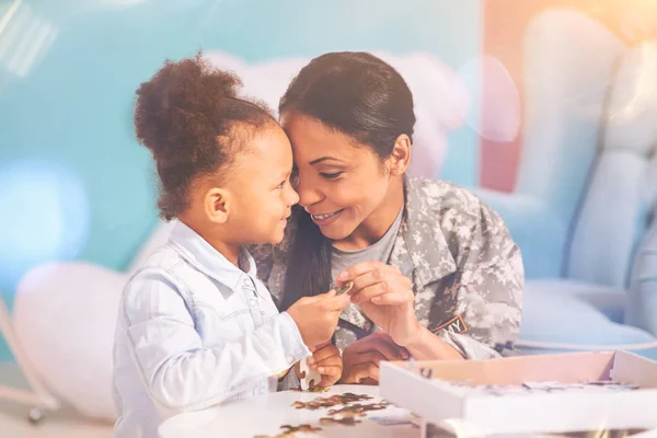 Madre e hija uniéndose mientras hacen un rompecabezas — Foto de Stock