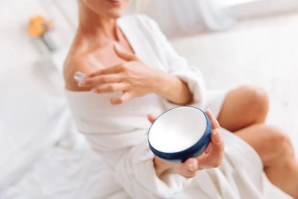 Woman holding blue package with cream — Stock Photo, Image