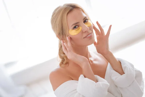 Mujer encantada haciendo masaje facial — Foto de Stock