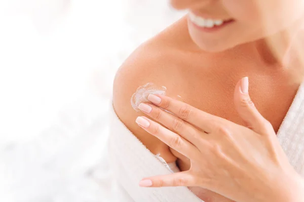 Delighted woman applying body lotion Royalty Free Stock Photos