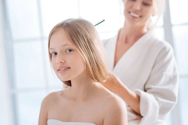 Жінка розчісує довге волосся дочки — стокове фото