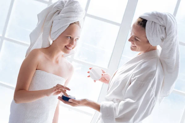 Mother giving package with cream to daughter — Stock Photo, Image