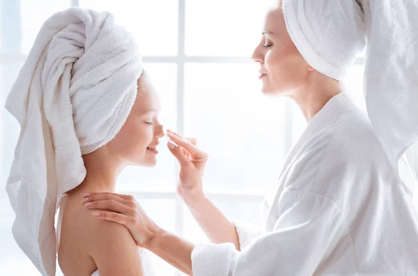 Moeder helpt dochter schoon gezicht — Stockfoto
