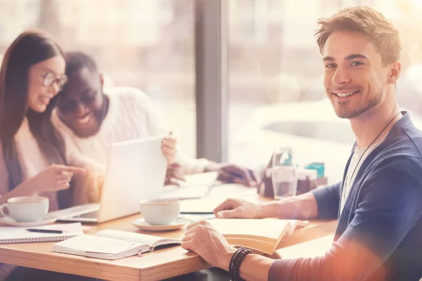 Studente seduto a tavola con i suoi amici — Foto Stock