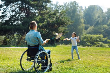 Genç Baba ile kızı badminton oynamaya tekerlekli sandalyede