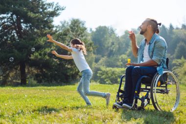 Baba ve kızı sabun köpüğü ile oynayan neşeli devre dışı