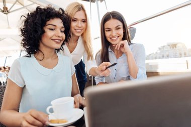 Dizüstü bilgisayar ekranına bakarak güzel neşeli kadınlar