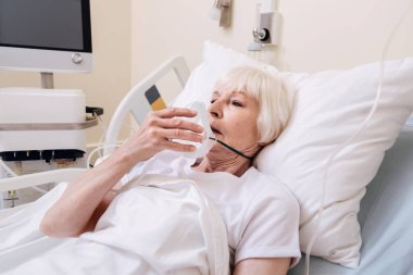 Ona oksijen maskeni alarak hassas acıyan kadın