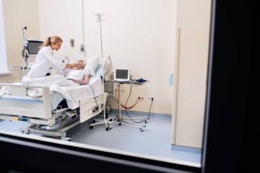 Özel bilge yetenekli kadın yaşlı hastasını kontrol