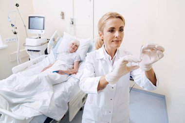 Dikkatli bir şırınga tutarak vicdanlı yetenekli doktor