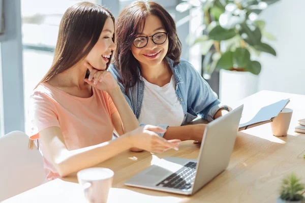 Neşeli mutlu arkadaşlar laptop ekrana bakarak