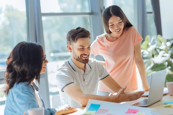 Vrolijke positieve man zit op de laptop — Stockfoto