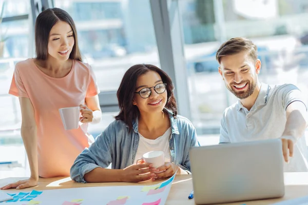 Dizüstü bilgisayar ekranına bakarak neşeli pozitif kişi