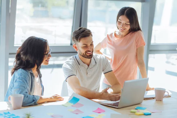 Knappe vrolijke man wijzend op de laptop — Stockfoto