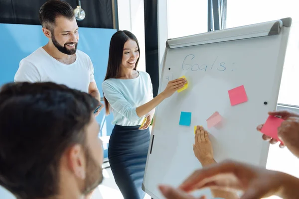 Mujer joven feliz sosteniendo una nota adhesiva — Foto de Stock