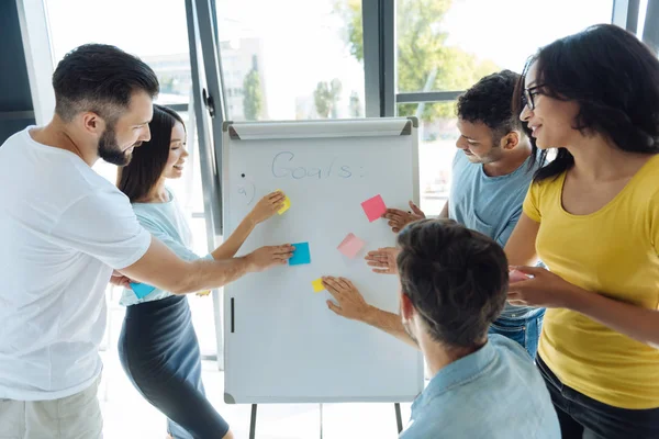 Vrolijke blij mensen staan rond het whiteboard — Stockfoto