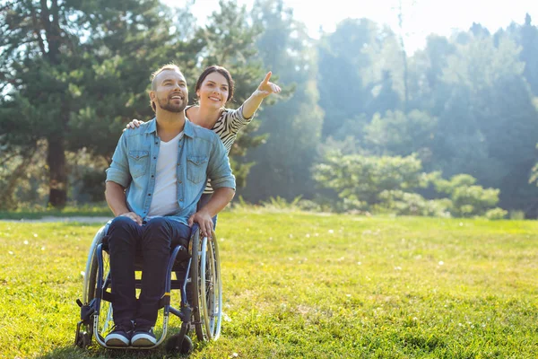 Femme montrant quelque chose à distance à son mari handicapé — Photo