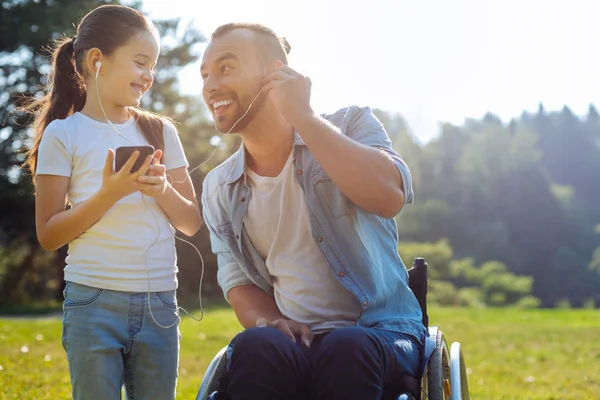 Père à mobilité réduite écoutant de la musique avec sa fille — Photo