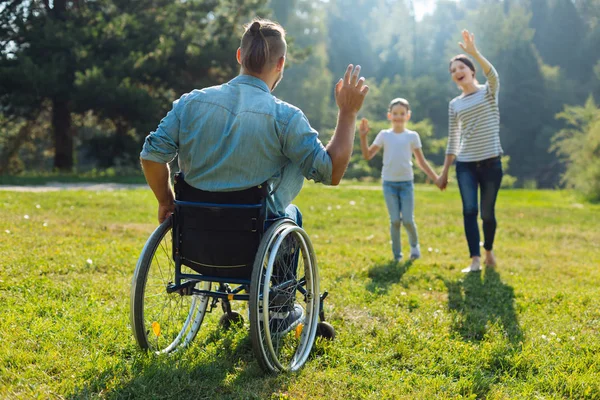 Jeune homme handicapé saluant sa famille — Photo