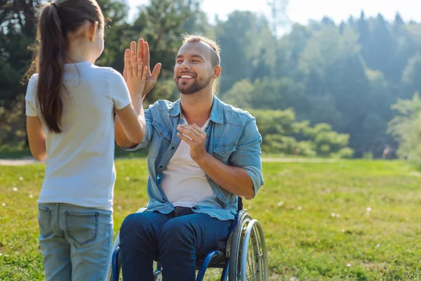 Petite fille donnant à son père handicapé un high five — Photo